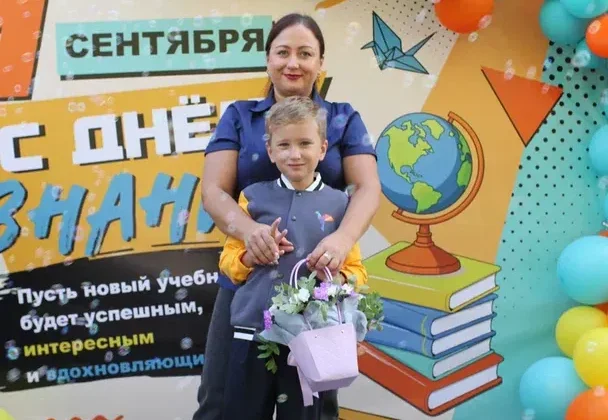 Ученик с мамой и букетом на празднике 1 сентября