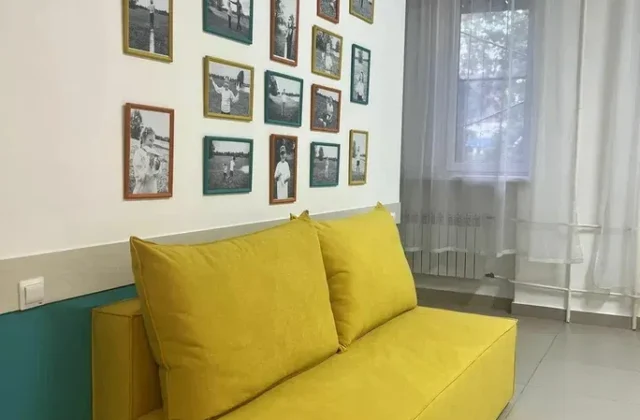 Зона отдыха с диваном и фотографиями на стене