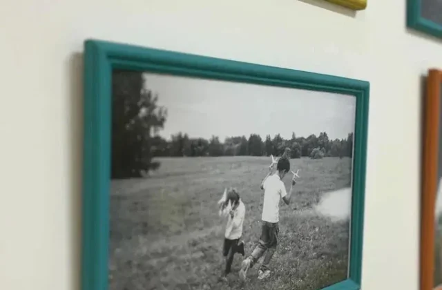 Фотографии в цветных рамках на стене школы